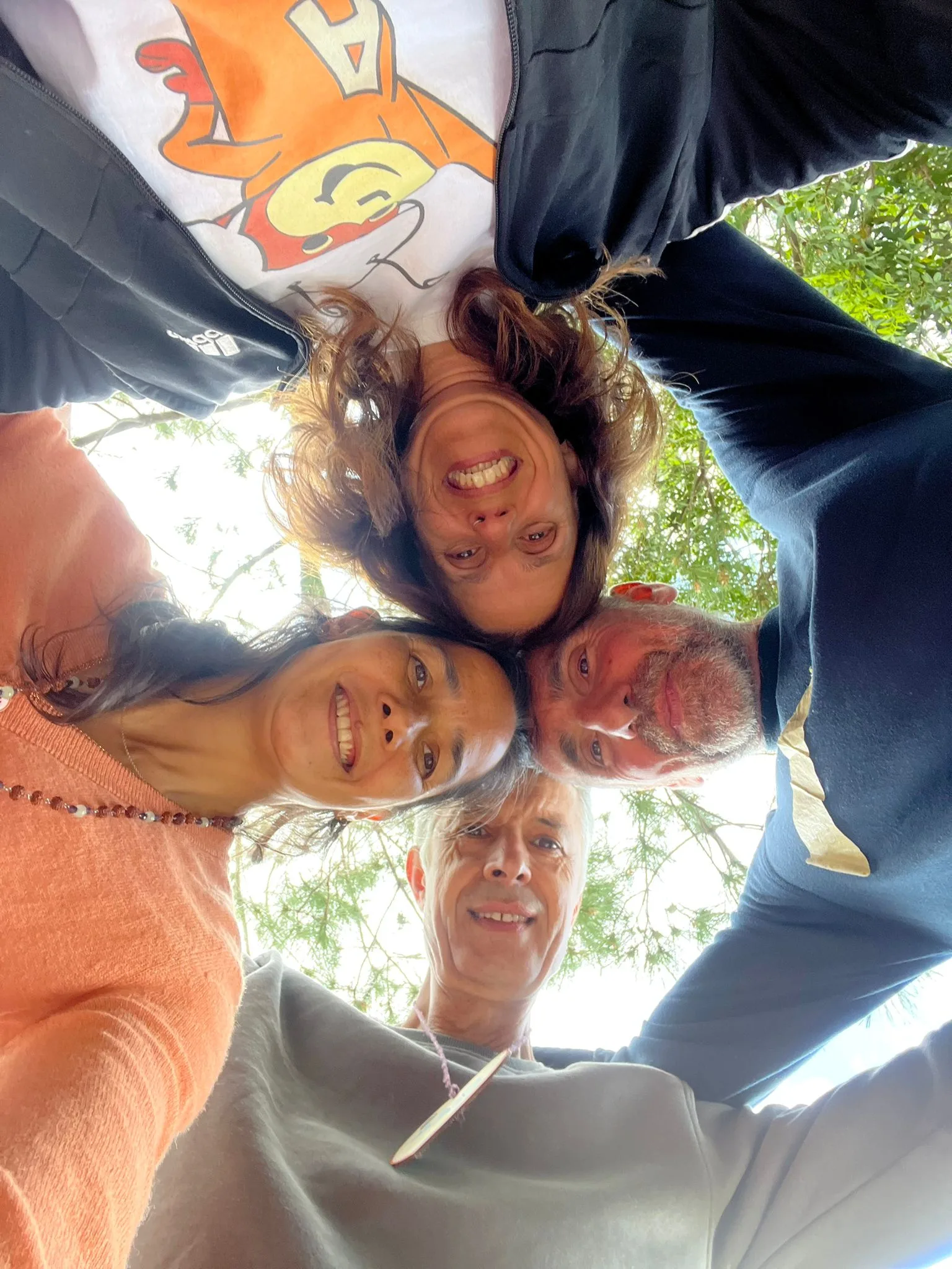 A group selfie huddle looking up at the camera, image 9 of 13